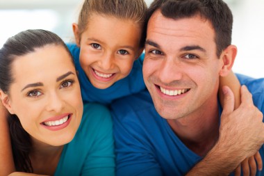 Family of three with bright smiles